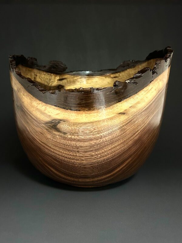 Dark bark-edge bowl. Deep dark bowl with a pale band beneath a textured bark edge.
