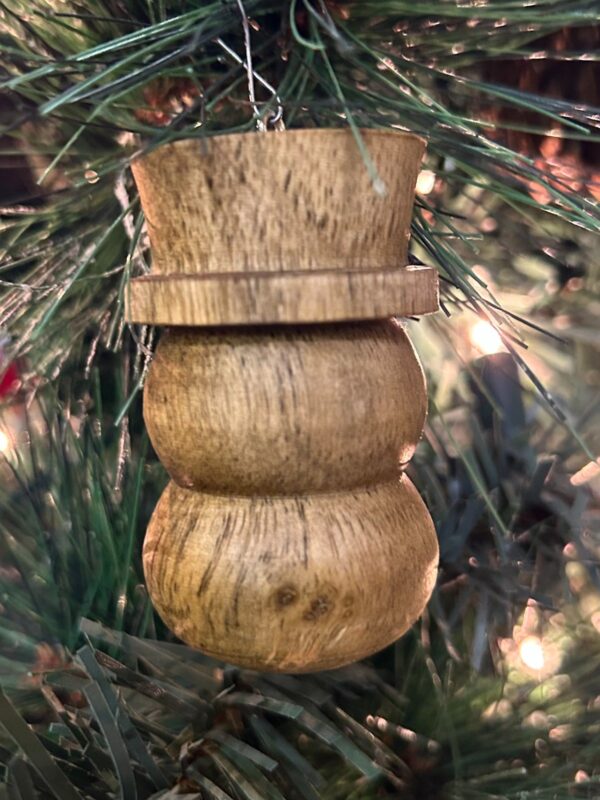 Stacked ornament. Small stacked wooden ornament hanging among tree branches.