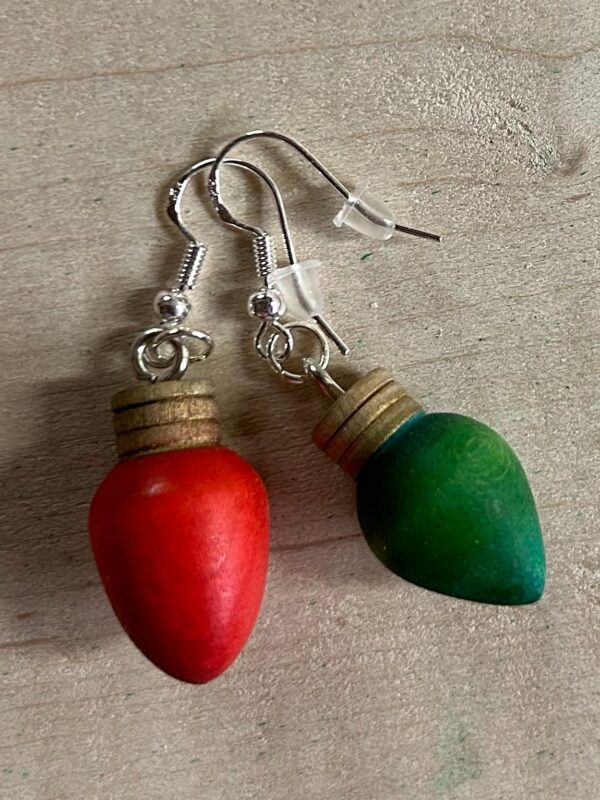Colorful earrings. Red and green rounded wooden earrings with metal hooks.