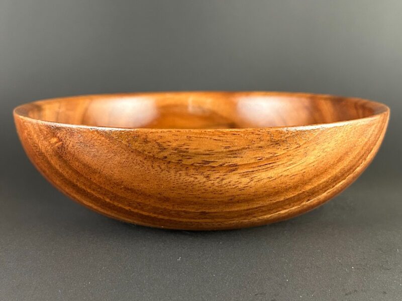 Warm shallow bowl. Shallow brown wooden bowl with flowing bands of warm grain.