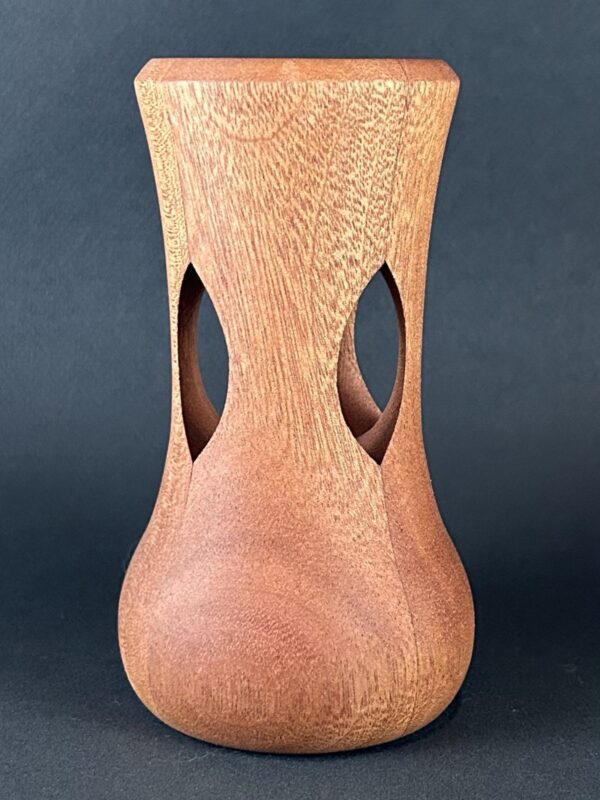 Cutout vessel. Tall vessel with curved sides and elongated openings through its middle.