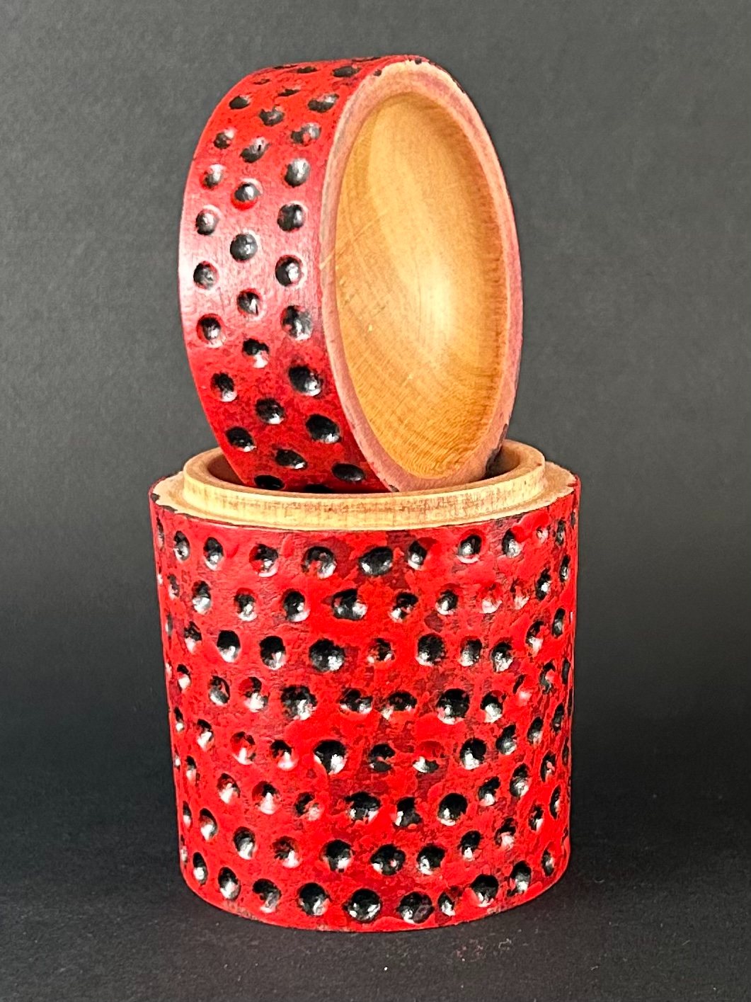 Red pierced box. Box with its lid lifted to show the interior.