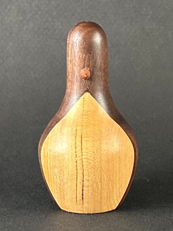 Penguin form. Upright wooden penguin form with a pale front and dark back.