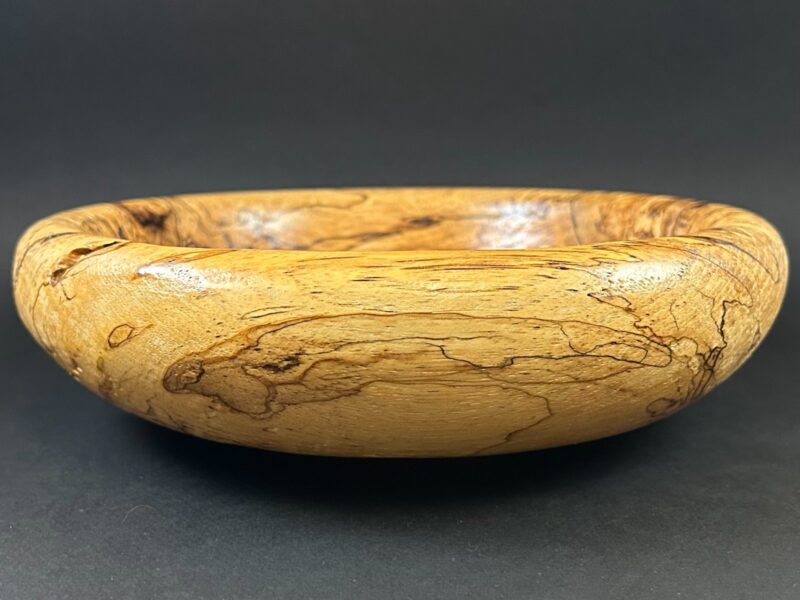 Traced-grain bowl. Low rounded bowl with dark lines and small natural openings.
