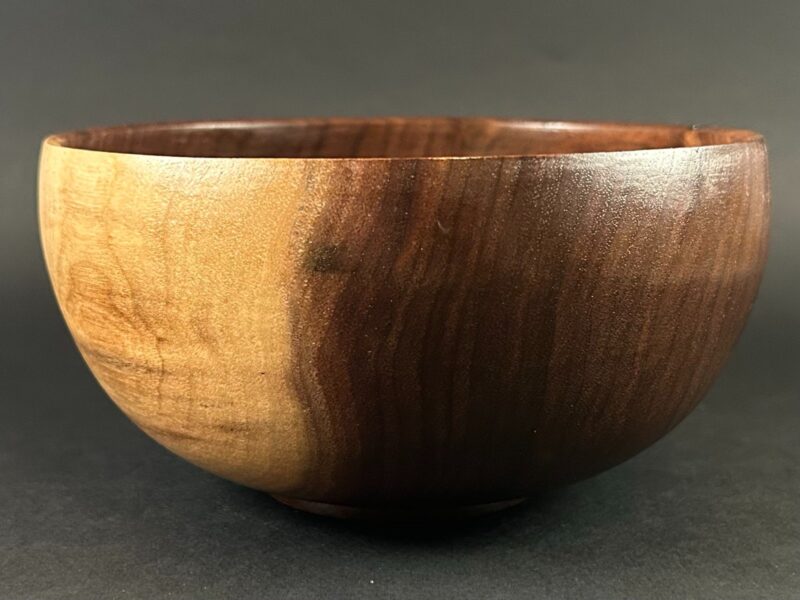 Two-tone bowl. Rounded bowl with a broad pale section beside deep brown grain.