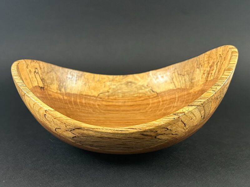 Marked-edge bowl. Curved wooden bowl with dark markings around the raised edges.