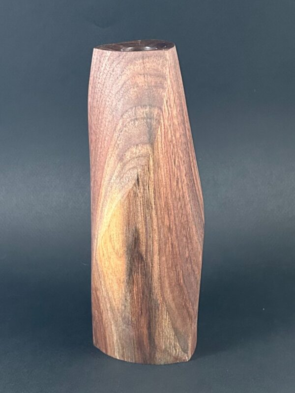 Tapered vessel. Tall tapered wooden vessel with reddish grain and a narrow opening.