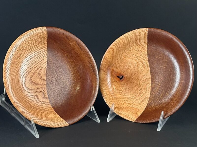 Contrasting dish pair. Two shallow wooden dishes on stands, each with contrasting pale and dark grain.