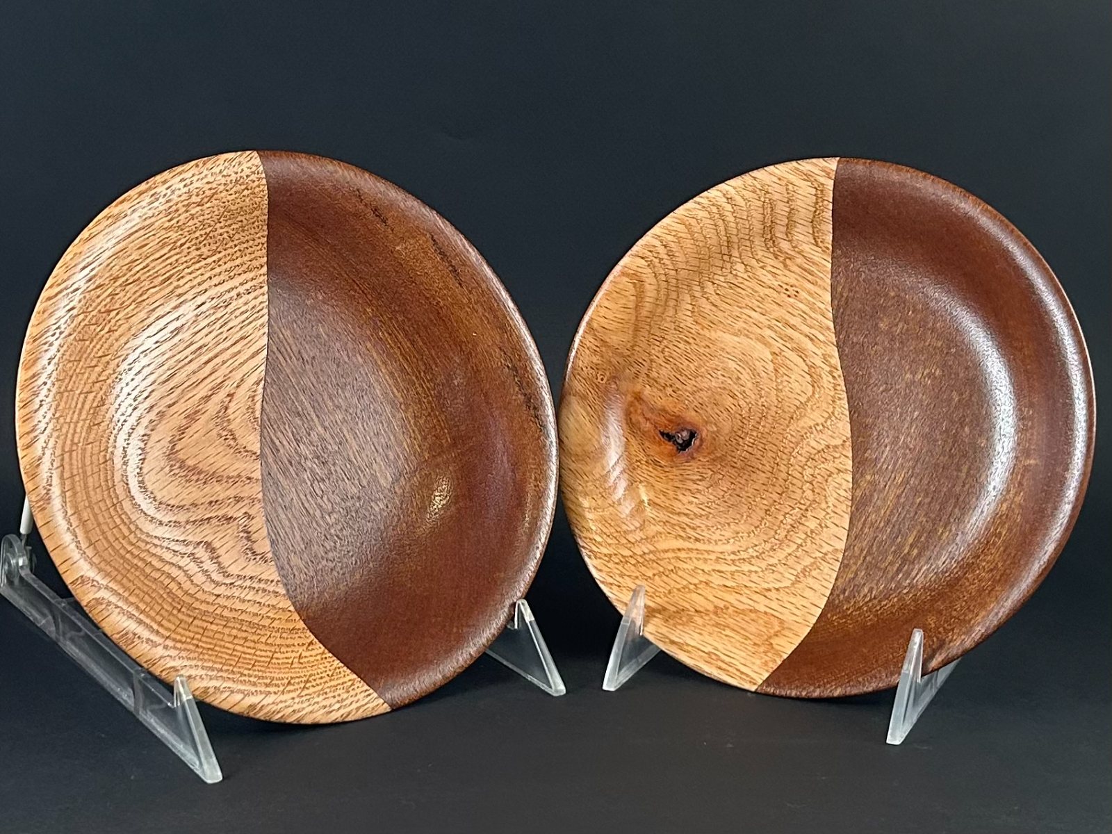Contrasting dish pair. Two shallow wooden dishes on stands, each with contrasting pale and dark grain.